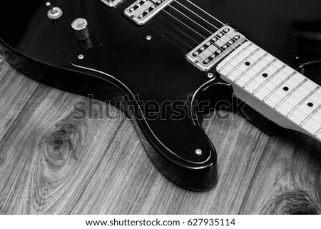 Electric guitar with wooden background in black and white picture. Old guitar is a friend to create a beautiful melody together for a long time.