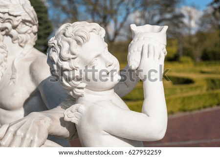 Statue of cupid with shell in the park.