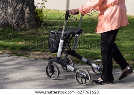 on a sunny day in spring seniority lady walks with rollator in park in south germany Royalty-Free Stock Photo #627961628