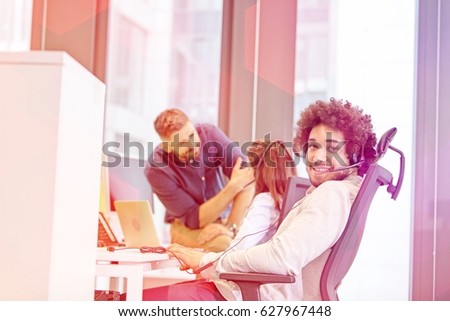 Portrait of male customer service representative with colleagues in background at office