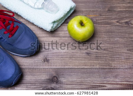 Sneakers, a towel, an apple and water
