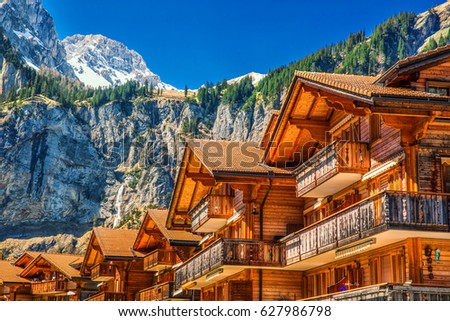 Colorful wooden houses with flowers in Kandersteg village, Canton Bern, Switzerland, Europe.  Royalty-Free Stock Photo #627986798
