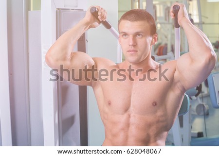 Athlete in the gym making vertical thrust. The power to exercise the muscles of the back. Photos for sporting magazines, posters and websites.