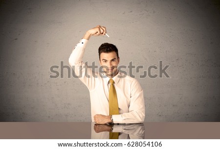 A happy businessman sitting at desk in front of clear grey empty background and drawing around himself with a white chalk concept