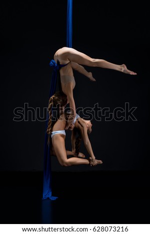 Girls exercising on blue aerial silks studio shot