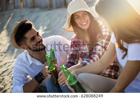 Group of happy friends partying on beach and having fun