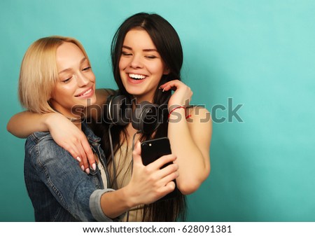 Two  girls friends in hipster outfit make selfie on a phone. 