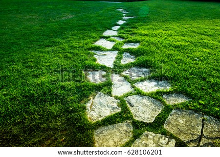 Stone Pathway on green grass Royalty-Free Stock Photo #628106201
