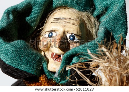 Color DSLR image of a spooky but smiling Halloween holiday witch doll with fangs, on white background, with copy space for text