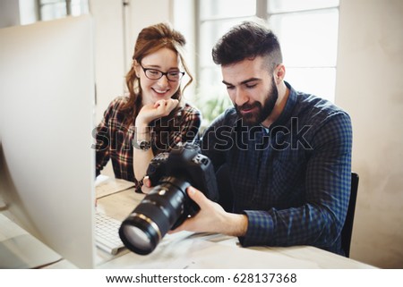 Company photo editor and photographer working together in office