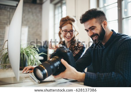 Company photo editor and photographer working together in office