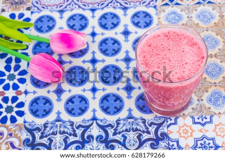 A cup of Strawberry Juice with mint leaves on an Oriental Colorful Background / Cup of Strawberry Juice on an Oriental Colorful Background with Flowers & mint leaves
