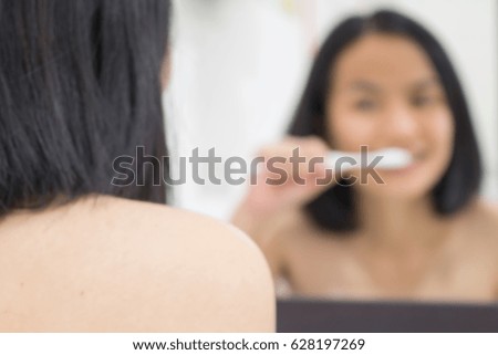 Blurred of 
A woman is brushing her teeth.