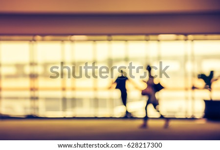 Blurred people walking at hallway in airport for background usage . (vintage tone)
