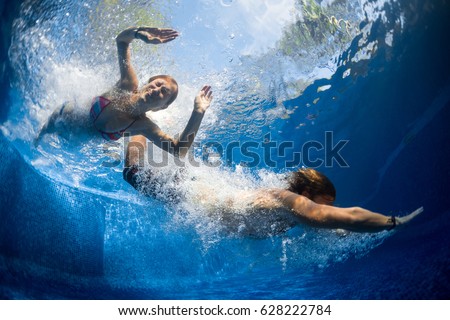 Underwater shot of couple jumping in the pool
