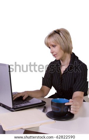 Isolated Businesswoman working on laptop with cup of coffee on her desk