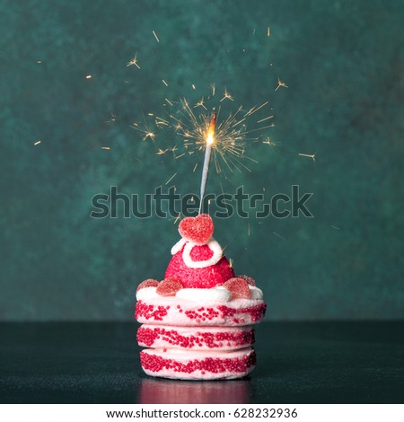 Sweet cake with sparkler decoration on dark background. Vintage style toned picture
