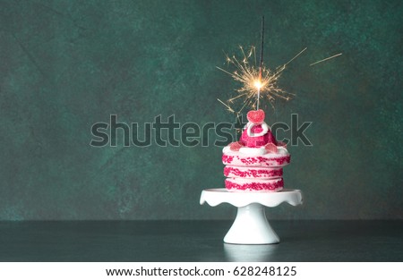 Birthday cake with sparkler decoration on dark background. Vintage style toned picture