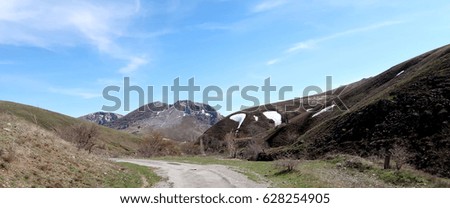 Gravel road in the mountains, spring landscape