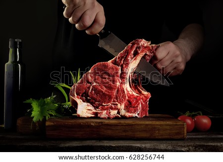 Man cutting raw beef meat. Royalty-Free Stock Photo #628256744