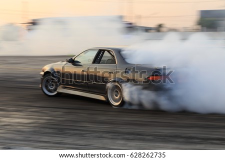 Race car drifting on speed track, Professional driver drifting car on race track with smoke, Abstract texture and background black tire tracks skid on asphalt road, Wheel tire tracks background. Royalty-Free Stock Photo #628262735