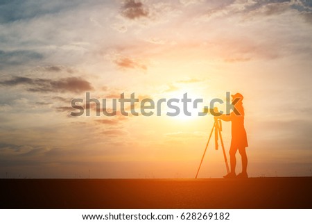 Silhouette of a photographer shoots a sunset.