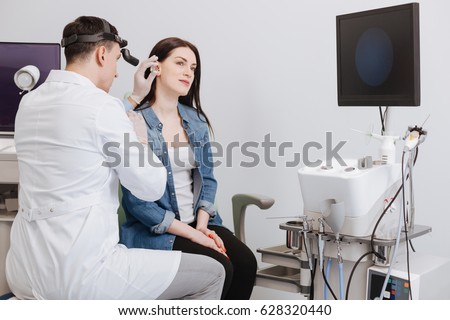 Ear nose throat doctor wearing headlight Royalty-Free Stock Photo #628320440