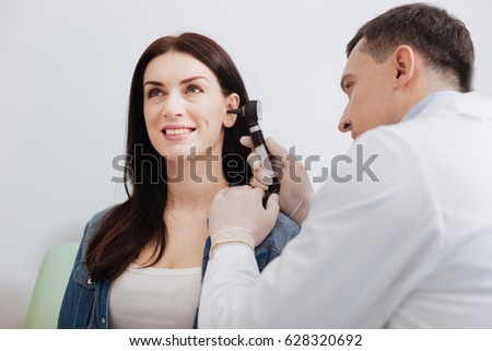 Attentive doctor doing ear exam of pretty woman Royalty-Free Stock Photo #628320692