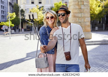 Couple taking selfie on city break, smiling