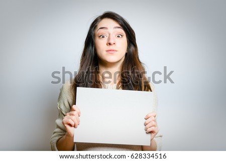 pretty girl shows blank banner for your text, isolated on gray background