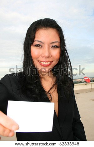 Asian woman holding white card.