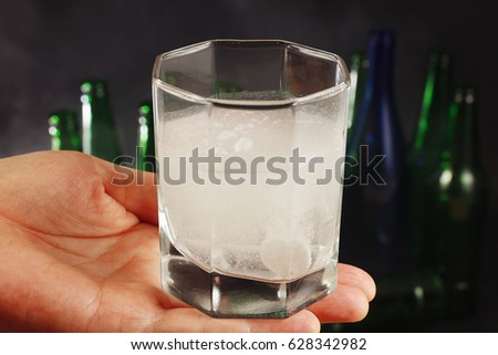Glass with a prepared drink from hangover on a dark background.