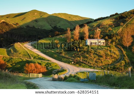 New Zealand rural road, house, and farm land  Royalty-Free Stock Photo #628354151