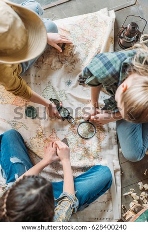 cute kids playing treasure hunt with map on porch Royalty-Free Stock Photo #628400240