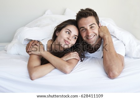 Good looking couple lying in bed, portrait