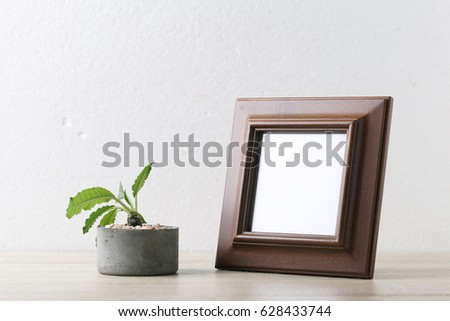 Photo frame with succulent plants in concrete pots on wooden table - vintage filter.