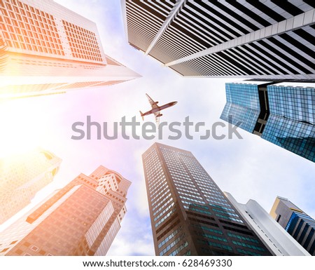 Business downtown skyscrapers and airplane in skies.