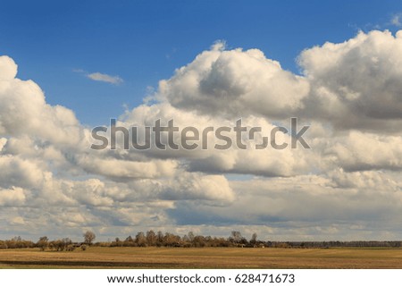 Field against the sky with clouds in the spring.