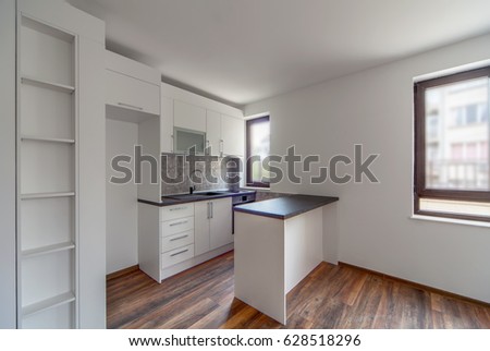 New modern and empty white kitchen. New home. Interior photography. Wooden floor.