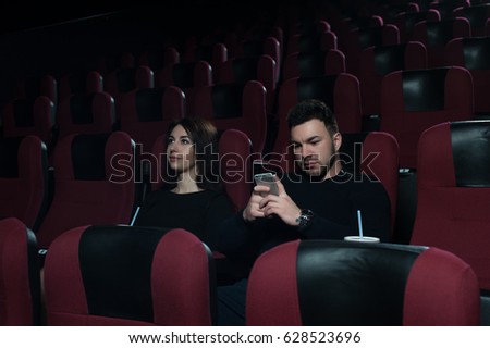 Romantic couple sitting in movie theater.