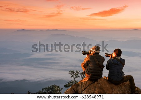 Photographer takes a picture of fog drifted massively floating above high mountain landscape in the morning ,Thailand.