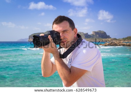 Landscape photographer with camera on tropical beach
