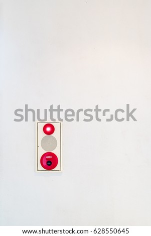 Fire alarm button on old white wall background.