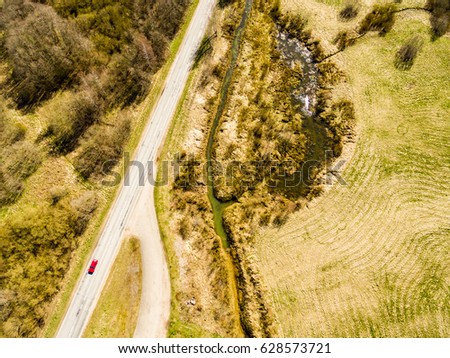 drone image. aerial view of rural area with river in forest in sunny spring day. latvia