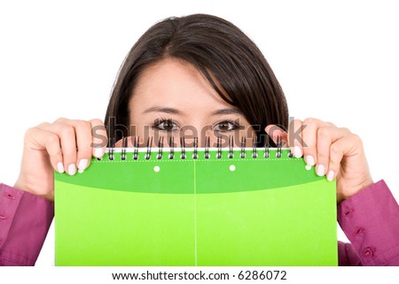 female college student peeping over a green notebook isolated over a white background