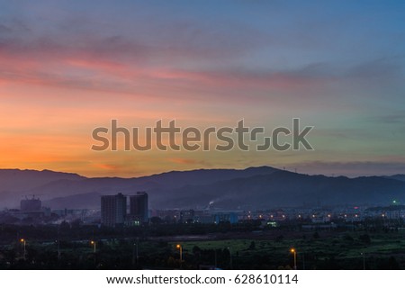 silhouette of construction site and tower crane in sunset sky background and under construction caption text below