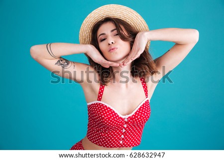 Beauty woman posing in studio and looking at the camera over blue background