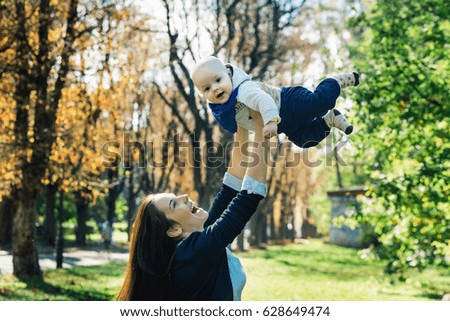 young mother playing with her baby. Mom and son walking in a park