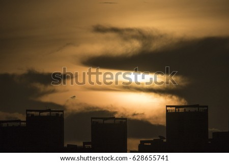 Skyscrapers in concrete jungle with clouds at sunrise