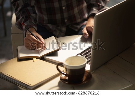 Closeup Novelist shot memo writing on paper notebook with vintage tone. Royalty-Free Stock Photo #628670216